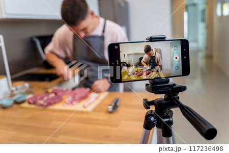 The chef is broadcasting live from workshop how to prepare a beef steaks on the electric grill 117236498