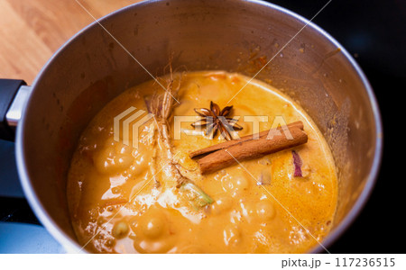 Chef at the kitchen preparing massaman curry with sweet potato and many spices Chef at the kitchen preparing massaman curry with sweet potato and many spices 117236515