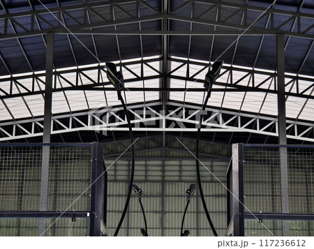 A large building with metal roof against a cloudy sky A large building with metal roof against a cloudy sky 117236612