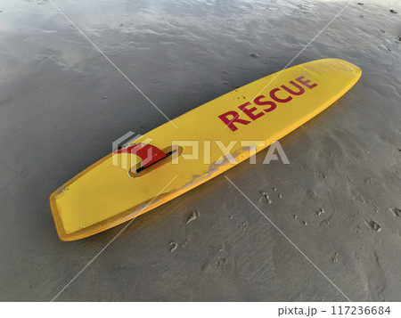 Bright yellow rescue surfboard at the ocean beach Bright yellow rescue surfboard at the ocean beach 117236684