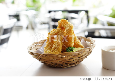 A close-up photo of a plate overflowing with golden fried calamari ring. A close-up photo of a plate overflowing with golden fried calamari ring. 117237024