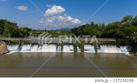 Aerial view of small spillway in Pa Daet district in Chiang Rai province of Thailand. Spillway, passage for surplus water over or around a dam when the reservoir itself is full. Aerial view of small spillway in Pa Daet district in Chiang Rai province of Thailand. Spillway, passage for surplus water over or around a dam when the reservoir itself is full. 117238198
