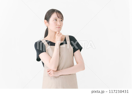 考える表情のエプロンをつけた女性店員 117238431