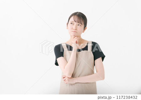 考える表情のエプロンをつけた女性店員 考える表情のエプロンをつけた女性店員 117238432