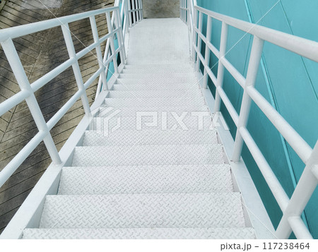 Metal stairs to blue building against sky and clouds 117238464