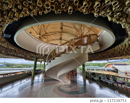 There is a spiral staircase in a building with a wooden railing There is a spiral staircase in a building with a wooden railing 117238751