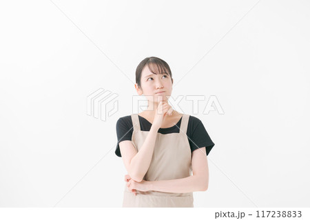 考える表情のエプロンをつけた女性 117238833