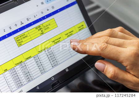 Close up shot of the woman with beautiful hands in the business attire, working on the laptop in the office, making notes Close up shot of the woman with beautiful hands in the business attire, working on the laptop in the office, making notes 117245284