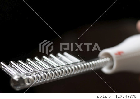 Close up shot of the high frequency comb tool for hair and scalp treatment. Close up shot of the high frequency comb tool for hair and scalp treatment. 117245879