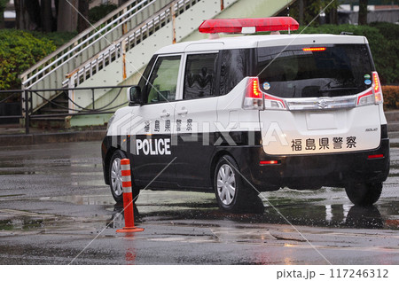 雨の日の道路を走る福島県警のパトカー 117246312