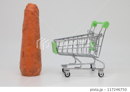 Poorly washed carrots stand next to a grocery cart, world food crisis, proper nutrition. 117246750
