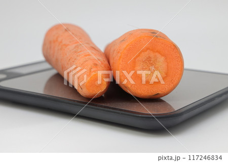 Poorly washed carrots lie on the kitchen electronic scales, carrots deteriorate, calorie counting Poorly washed carrots lie on the kitchen electronic scales, carrots deteriorate, calorie counting 117246834