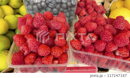 Raspberries and blueberries in containers. Foodstuffs and fruits. Harvest and market. Healthy eating. Raspberries and blueberries in containers. Foodstuffs and fruits. Harvest and market. Healthy eating. 117247187
