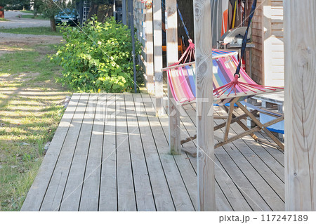 Hammock on wooden terrace of old barn near sea at beach. Nature and recreation. Meditation and relaxation. Background for text and design. 117247189