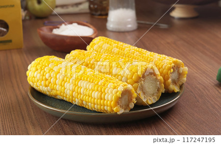 Fresh sweet cooked corn fruit on plate. Food and cooking. Nutrition and health. Background for design. Fresh sweet cooked corn fruit on plate. Food and cooking. Nutrition and health. Background for design. 117247195