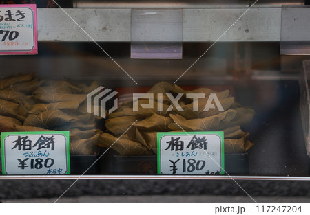 Traditional handmadeKashiwa mochi dispaly in the store. it's a wagashi (Japanese confection) of white mochi surrounding a sweet anko (red bean paste) filling with a kashiwa (oak) leaf  117247204