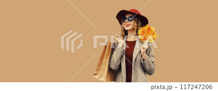 Autumn portrait, beautiful elegant happy woman with shopping bag holding yellow maple leaves in hat Autumn portrait, beautiful elegant happy woman with shopping bag holding yellow maple leaves in hat 117247206