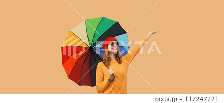 Autumn beautiful happy cheerful young woman holds colorful umbrella enjoys new season in sweater 117247221