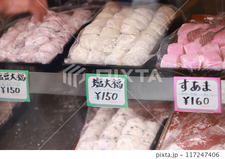 traditional handmade Daifuku is displayed in a store on the street of Sugamo in Tokyo. Daifuku is a type of Japanese confection, consisting of a small round mochi stuffed with a sweet filling. traditional handmade Daifuku is displayed in a store on the street of Sugamo in Tokyo. Daifuku is a type of Japanese confection, consisting of a small round mochi stuffed with a sweet filling. 117247406