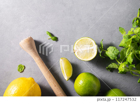 Flat lay ingredients cocktail with lime, fresh mint and lemon on gray texture background. Flat lay ingredients cocktail with lime, fresh mint and lemon on gray texture background. 117247532