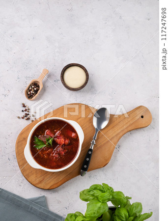 Traditional beetroot soup (Borscht) on light background with sour cream and fresh herb.  117247698