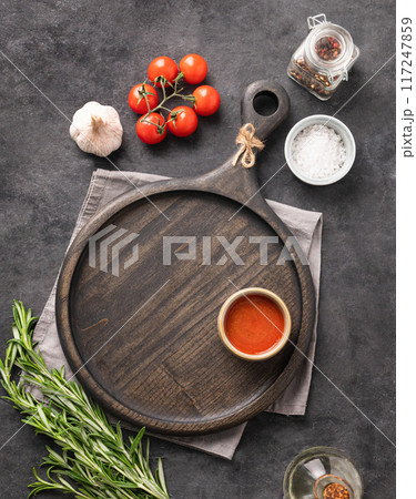 A cutting board for serving food and cooking with sauce, spices, herbs and tomatoes A cutting board for serving food and cooking with sauce, spices, herbs and tomatoes 117247859
