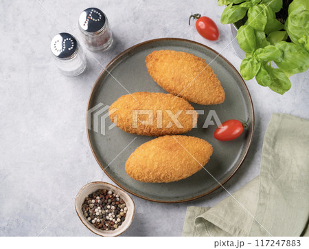 Chicken Kiev cutlets on a plate with fresh tomatoes, herbs and spices. Chicken Kiev cutlets on a plate with fresh tomatoes, herbs and spices. 117247883
