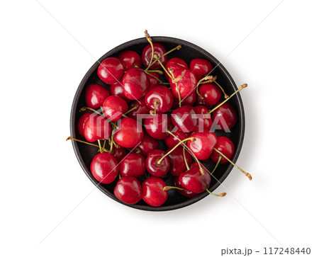 Fresh cherries in a black bowl on a white isolated  background. Top view and copy space 117248440