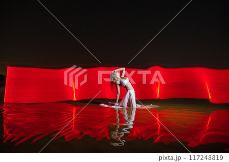Young slim girl posing in water with abstract red light effect 117248819