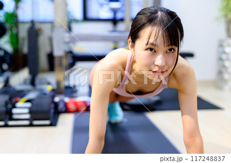 パーソナルジムで体を鍛える若い女性　筋トレ女子　腕立て伏せ　プランク　 117248837