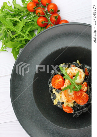 Black spaghetti. Black seafood pasta in white plate on black background with copy space. Black spaghetti. Black seafood pasta in white plate on black background with copy space. 117249277