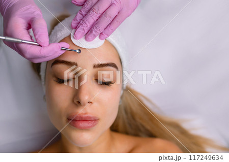 A procedure for mechanical or manual face cleansing by a beautician. Professional skin peeling. Hygiene for the skin 117249634