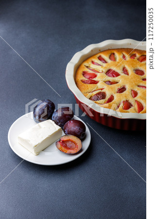 Freshly Baked Plum Cake With Butter and Plums on a Dark Background Freshly Baked Plum Cake With Butter and Plums on a Dark Background 117250035