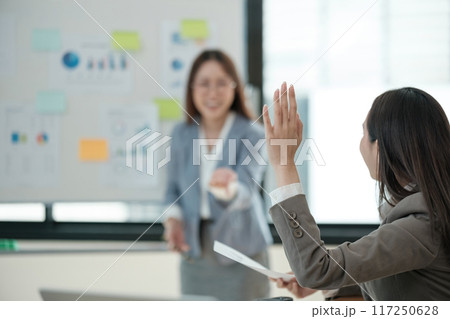 A woman is giving a presentation to a group of people 117250628