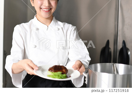 肉料理を提供する若いアジア人の女性調理師 117251918