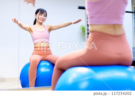 スポーツジムでバランスボールに乗る若い女性 ダイエット パーソナルジム 筋トレ女子 フィットネス スポーツジムでバランスボールに乗る若い女性 ダイエット パーソナルジム 筋トレ女子 フィットネス 117254202