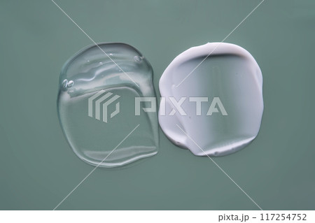 Facial serum and cream on a green background. Texture. 117254752