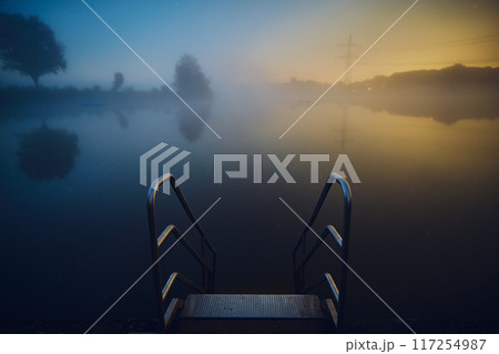 stairs into lake at night with fog 117254987