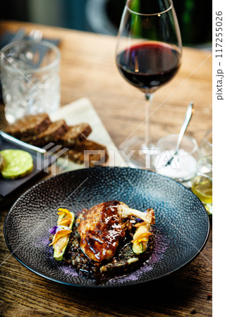 Corn chicken supreme. Beluga lentils, Old Ammerlander cheese, mini zucchini, red wine sauce. Delicious healthy traditional food closeup served for lunch in modern gourmet cuisine restaurant Corn chicken supreme. Beluga lentils, Old Ammerlander cheese, mini zucchini, red wine sauce. Delicious healthy traditional food closeup served for lunch in modern gourmet cuisine restaurant 117255026