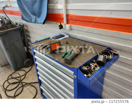 Tools for car repair are laid out in a car repair shop. Empty car repair workshop. Workshop concept with tools without people. 117255576