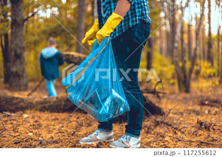 Mother and son eco activists collect garbage in the forest The family takes care of saving the forest from garbage. A woman teaches her child to take care of nature and clean up trash. Saving nature. Mother and son eco activists collect garbage in the forest The family takes care of saving the forest from garbage. A woman teaches her child to take care of nature and clean up trash. Saving nature. 117255612