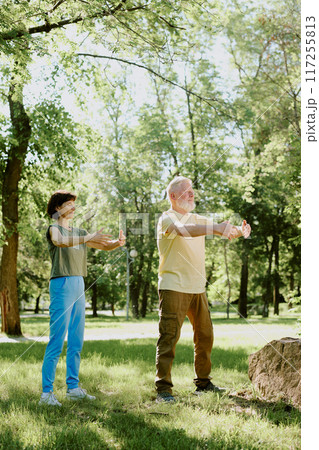 Senior Couple breathing in fresh summer air in park during meditation practice 117255813