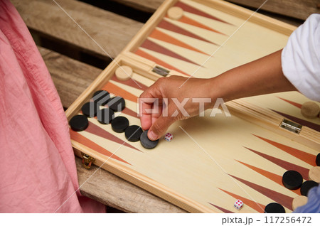 A mother and daughter spend quality time baking croissants together in a cozy kitchen. The little girl thoughtfully arranges baked goods while learning the art of cooking. 117256472