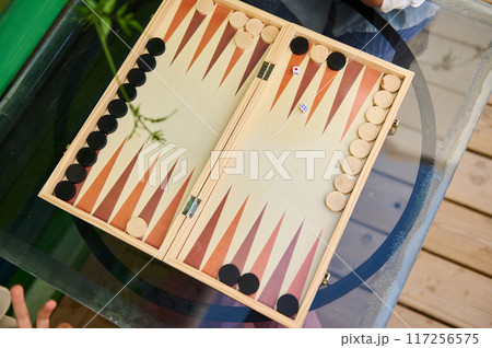 Top view of a backgammon game in progress on a glass table Top view of a backgammon game in progress on a glass table 117256575