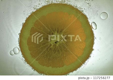 Slice of orange in sparkling water. Orange fruit slice covered by bubbles in carbonated water. Orange slice in water with bubbles Slice of orange in sparkling water. Orange fruit slice covered by bubbles in carbonated water. Orange slice in water with bubbles 117258277