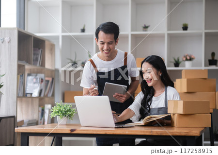 A couple of online sellers work together to take online orders and pack products for delivery to customers. A couple of online sellers work together to take online orders and pack products for delivery to customers. 117258915