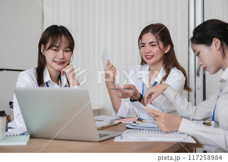 A group of Asian businesswomen in a conference room are discussing ways of working and improving their work. A group of Asian businesswomen in a conference room are discussing ways of working and improving their work. 117258984