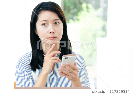 リビングでスマホを見る女性 リビングでスマホを見る女性 117259534