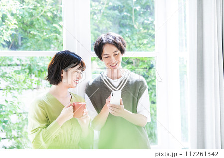 スマホで検索する若い夫婦 スマホで検索する若い夫婦 117261342