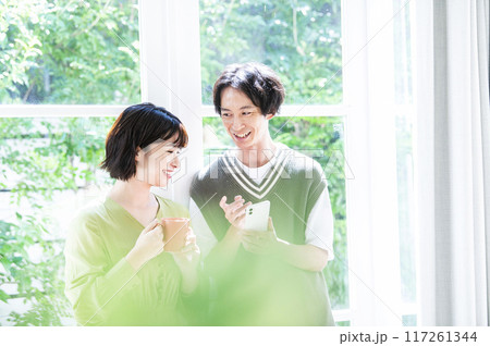 スマホで検索する若い夫婦 117261344